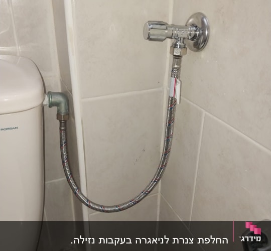 ברז מים מחובר לאסלה בחדר אמבטיה
